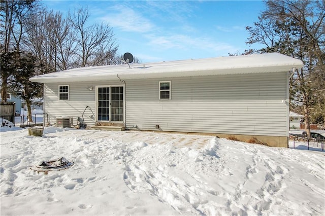 snow covered rear of property featuring central air condition unit