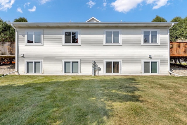 rear view of house featuring a yard and a wooden deck