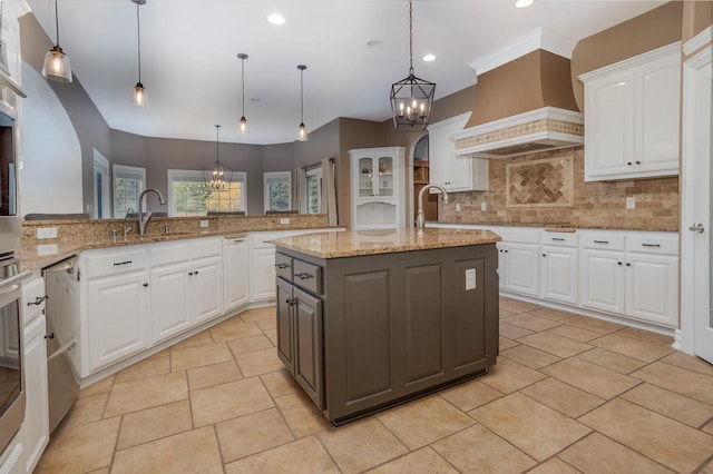 kitchen featuring pendant lighting, an island with sink, white cabinets, and custom exhaust hood