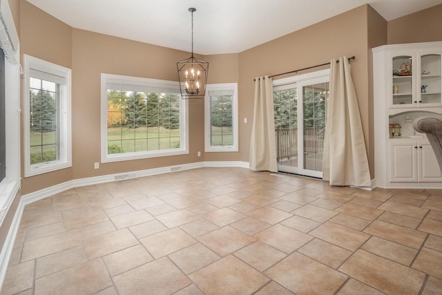 unfurnished dining area with baseboards, an inviting chandelier, and visible vents