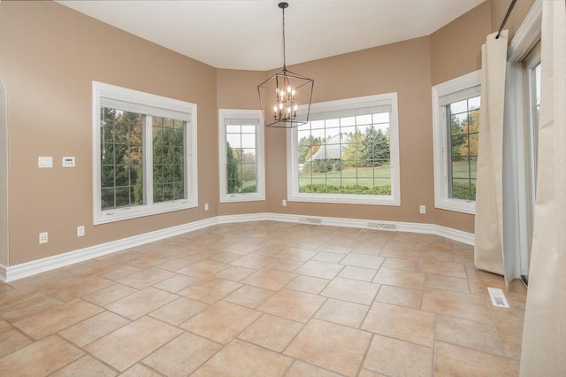 unfurnished dining area featuring plenty of natural light, baseboards, a notable chandelier, and visible vents