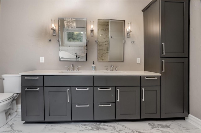 bathroom featuring double vanity, toilet, marble finish floor, and a sink