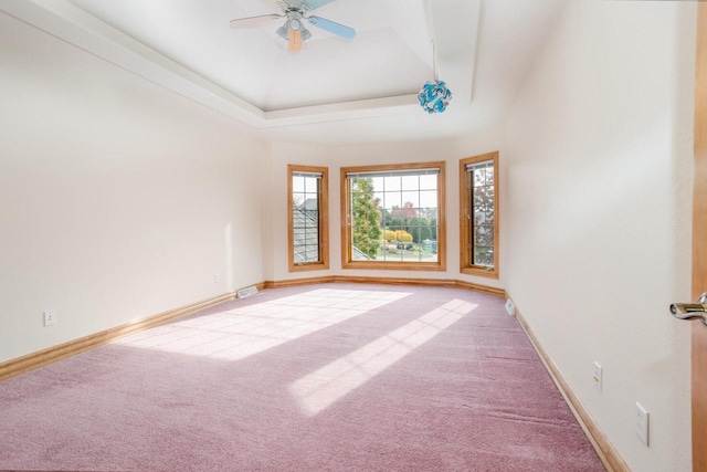 spare room featuring baseboards, a raised ceiling, light colored carpet, and visible vents