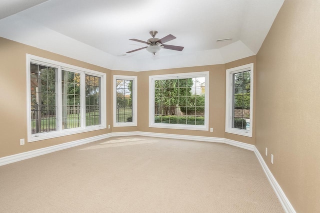 unfurnished sunroom with ceiling fan and a tray ceiling