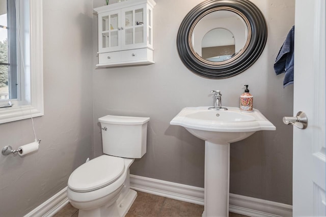 bathroom featuring toilet, baseboards, and tile patterned floors