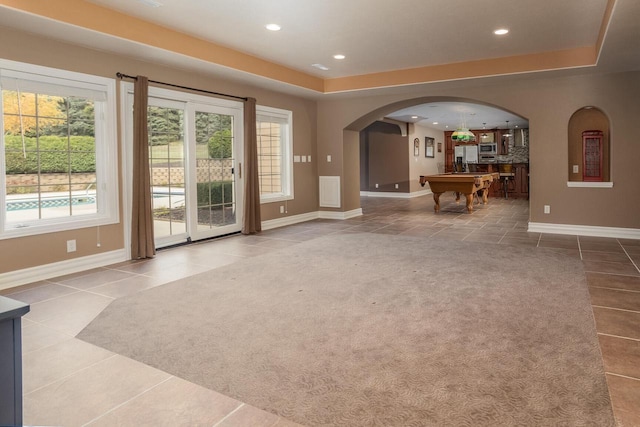 interior space featuring recessed lighting, light carpet, baseboards, and arched walkways