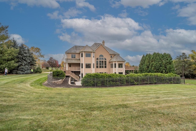 back of property featuring a lawn, fence, and a chimney