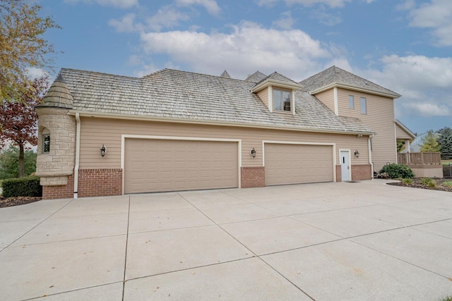 view of front of property featuring brick siding, driveway, and a garage