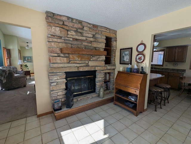 tiled living room with sink, a textured ceiling, and a fireplace