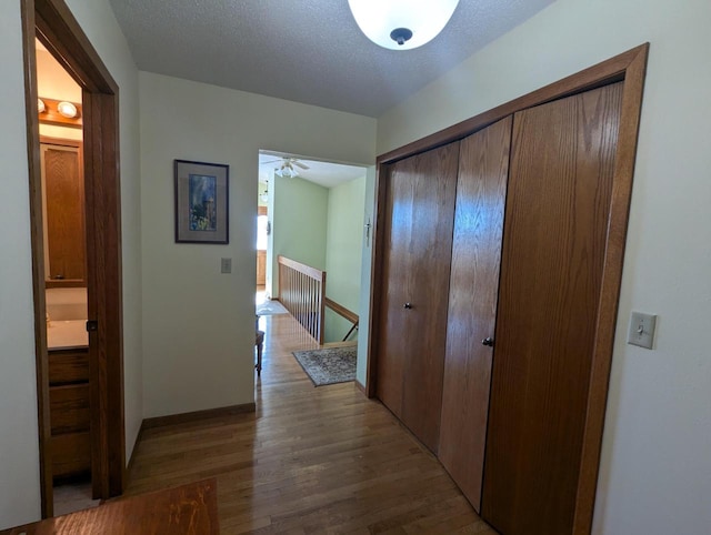 hall featuring a textured ceiling and wood-type flooring