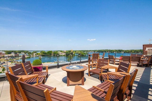 view of patio with a water view and a fire pit