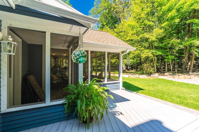 wooden terrace with a sunroom and a lawn