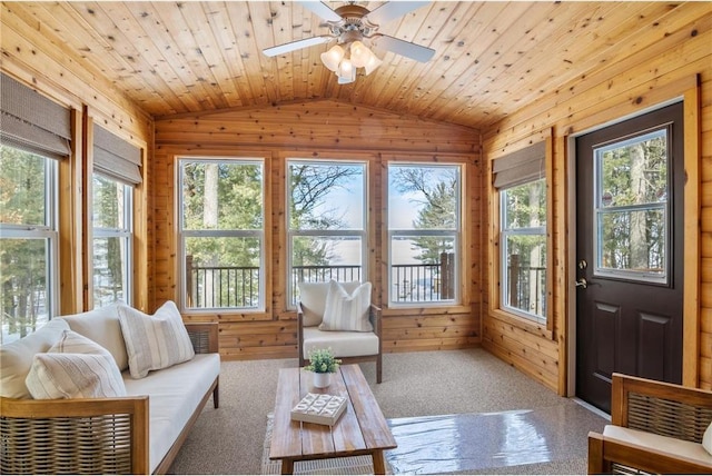 sunroom featuring lofted ceiling, ceiling fan, wood ceiling, and a healthy amount of sunlight