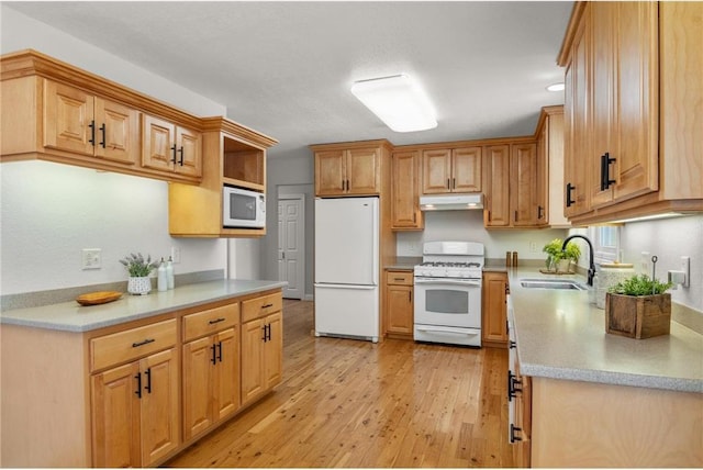 kitchen featuring under cabinet range hood, white appliances, a sink, light wood-style floors, and light countertops