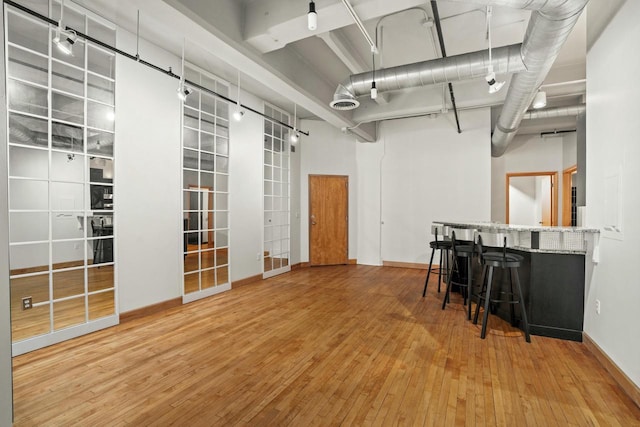 below grade area featuring baseboards, visible vents, and wood finished floors