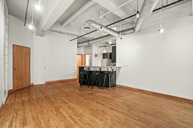 interior space with freestanding refrigerator, baseboards, and visible vents