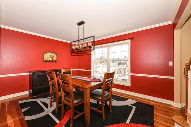 dining room with baseboards, dark wood-style floors, a notable chandelier, and ornamental molding