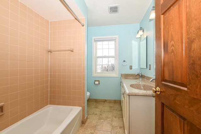 bathroom with a sink, baseboards, toilet, and double vanity