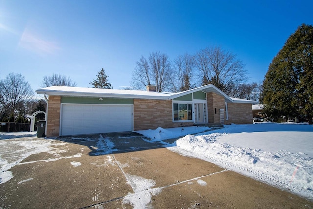 view of front of house featuring stone siding, driveway, and an attached garage