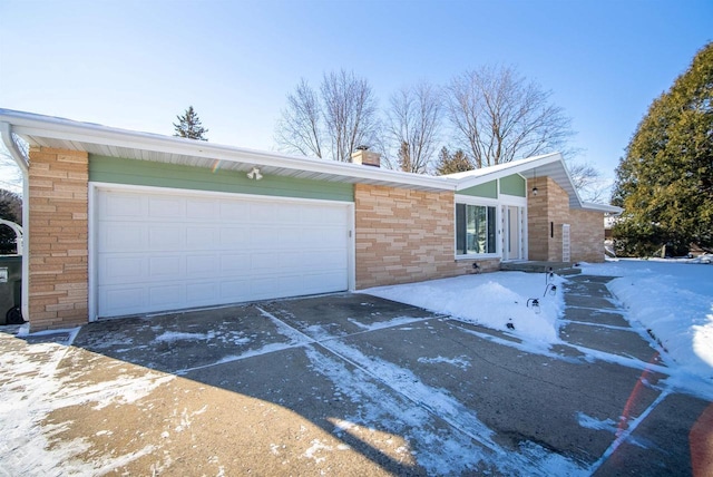 view of front of home with an attached garage, stone siding, driveway, and a chimney