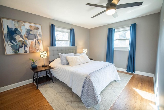 bedroom with a ceiling fan, light wood-type flooring, and baseboards