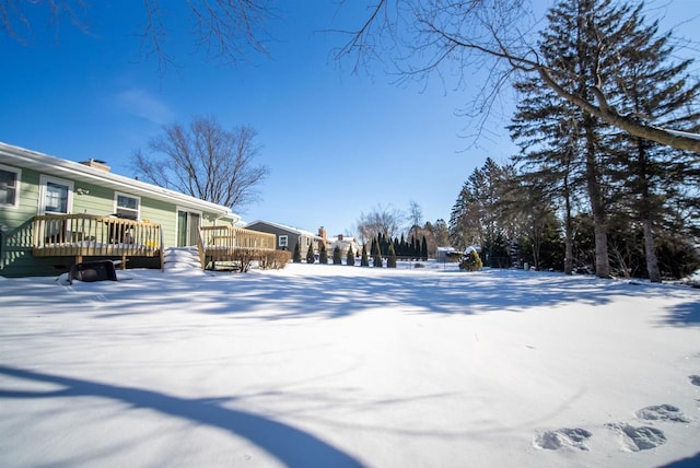 yard covered in snow featuring a wooden deck