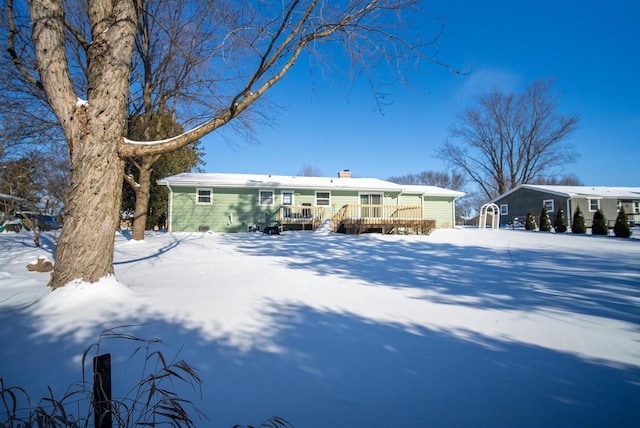 snow covered house featuring a wooden deck