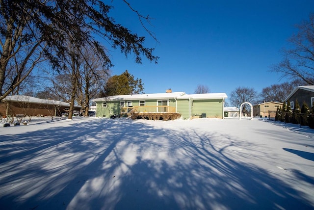 snow covered property with a chimney