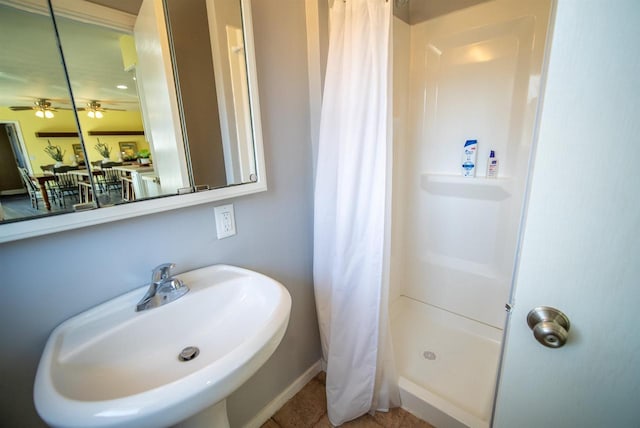 bathroom with ceiling fan, tile patterned floors, a stall shower, and a sink