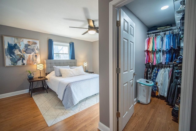 bedroom with ceiling fan, a closet, baseboards, and wood finished floors