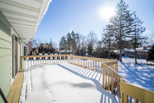 snowy yard with a deck and a patio area