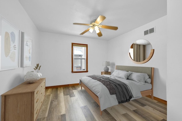 bedroom with baseboards, ceiling fan, visible vents, and light wood-style floors