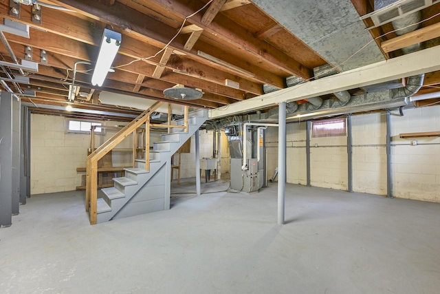 basement featuring stairs and heating unit