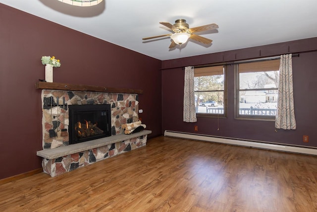 unfurnished living room with wood finished floors, a ceiling fan, a baseboard radiator, and a fireplace