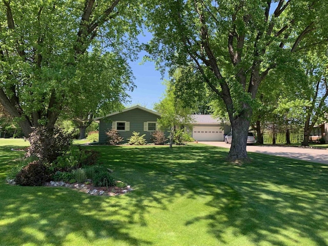 view of front facade featuring a front lawn, driveway, and a garage