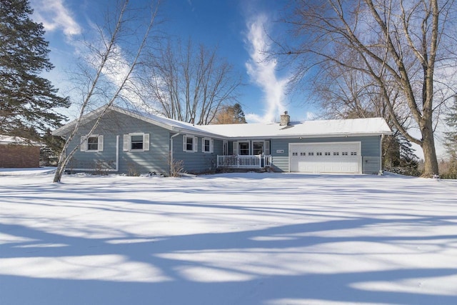 ranch-style house featuring a porch, a chimney, driveway, and an attached garage