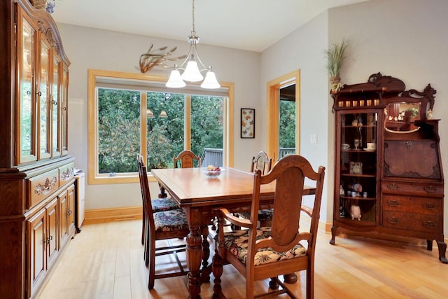 dining space with baseboards and light wood-style floors