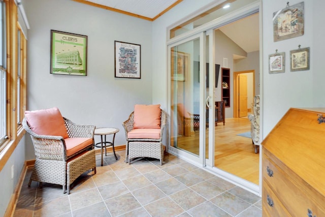 living area featuring french doors, ornamental molding, baseboards, light tile patterned flooring, and lofted ceiling