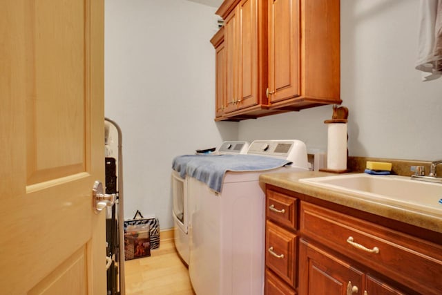 laundry area featuring a sink, independent washer and dryer, and cabinet space