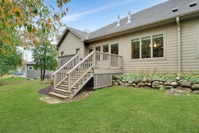 rear view of house with a wooden deck, stairs, a shingled roof, and a lawn