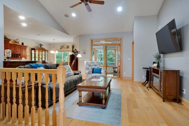 living area featuring light wood-style flooring, baseboards, recessed lighting, ceiling fan with notable chandelier, and vaulted ceiling