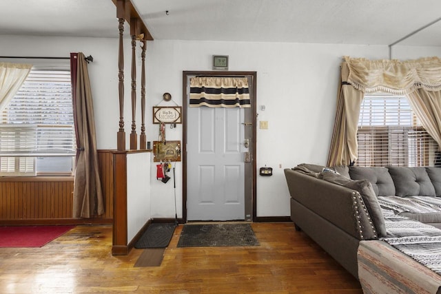 foyer entrance featuring baseboards, dark wood-style floors, and radiator