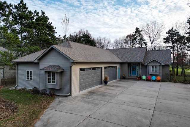 single story home featuring roof with shingles, driveway, and an attached garage