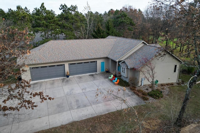 view of front of house featuring a shingled roof, an attached garage, and concrete driveway