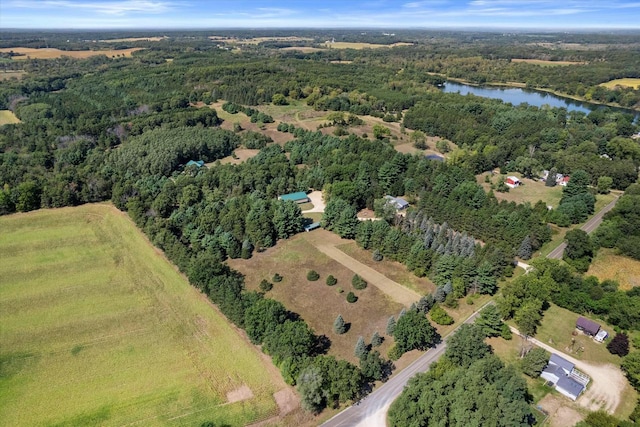 drone / aerial view with a water view and a forest view