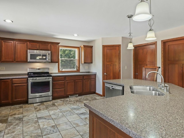 kitchen featuring a sink, visible vents, hanging light fixtures, appliances with stainless steel finishes, and brown cabinetry