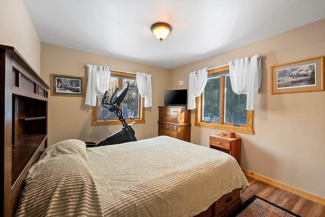 bedroom featuring baseboards and wood finished floors