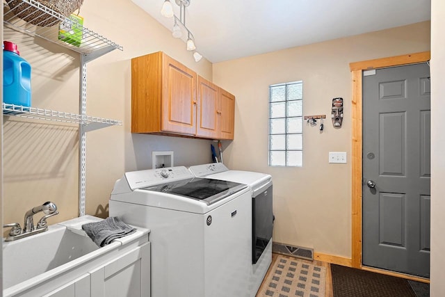 laundry area with a sink, visible vents, baseboards, independent washer and dryer, and cabinet space