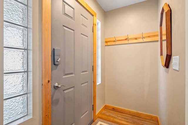 doorway to outside with a wealth of natural light, light wood-style flooring, and baseboards