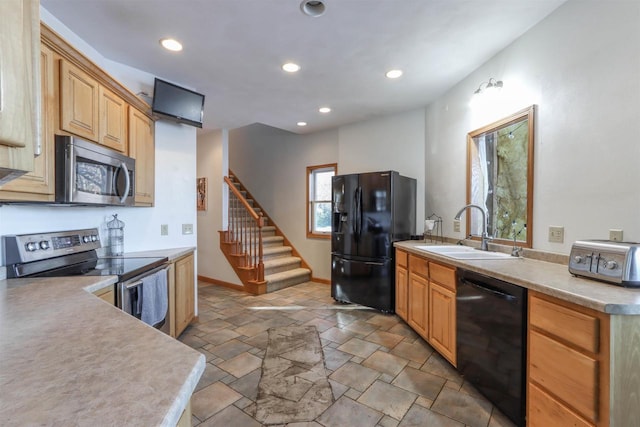 kitchen with a toaster, stone tile floors, light countertops, a sink, and black appliances